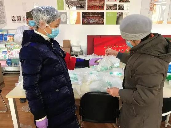 為樓棟分發(fā)口罩，并為包裝袋消毒